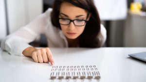 Are Autism and OCD Related A woman intensely focusing on arranging objects in a straight line, symbolizing repetitive behaviors associated with autism and OCD