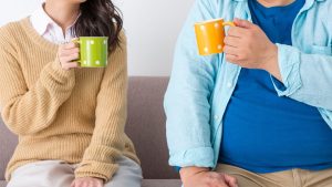 AuDHD vs ADHD: Key Differences Everyone Should Know Two people sitting side by side with coffee mugs, symbolizing communication and connection—illustrating differences between AuDHD and ADHD in social interaction.
